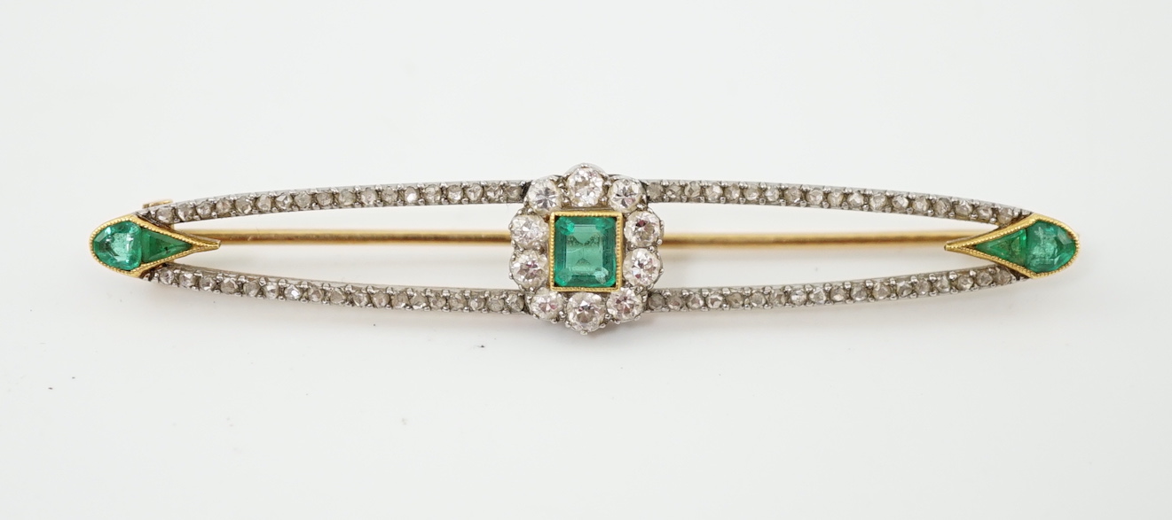 A Belle Epoque gold and platinum, emerald and round cut diamond cluster set elliptical bar brooch
